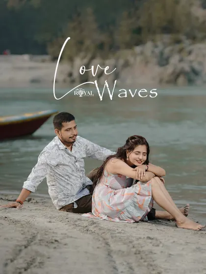 A sweet shot of a couple sitting on the sand by the river, titled 'Love Waves', perfectly capturing a relaxed beach vibe.