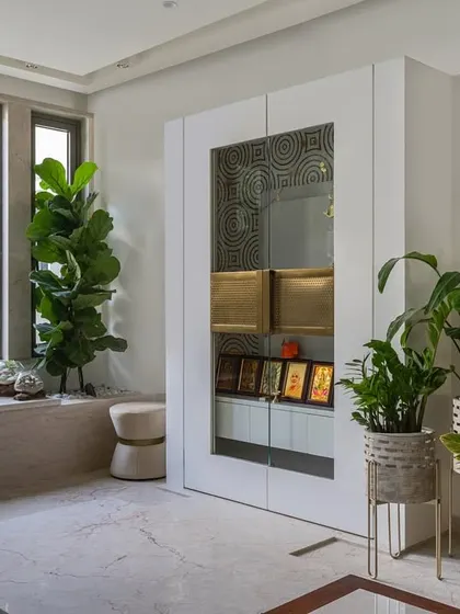 Creating a sacred space within a home is a special responsibility. This Vastu-compliant temple area from our 'Enchanted Eco' project uses clean white lines, natural light, and lush greenery to create a serene and tranquil corner for meditation and peace.