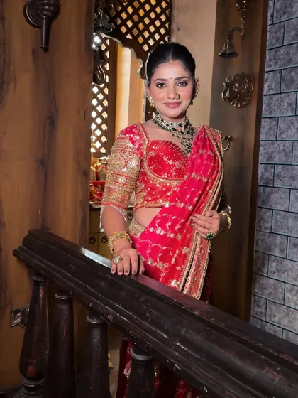 A classic bridal pose on the stairs. The drape of this red saree is carefully managed to look neat and flattering from every angle.