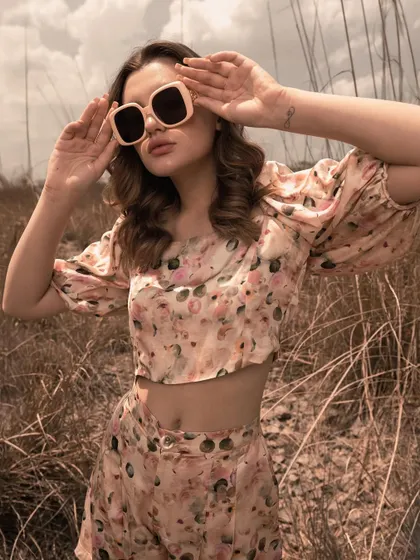 A playful, sun-drenched shot focusing on the floral co-ord set and sunglasses. This image captures a youthful, carefree vibe, perfect for a social media campaign.
