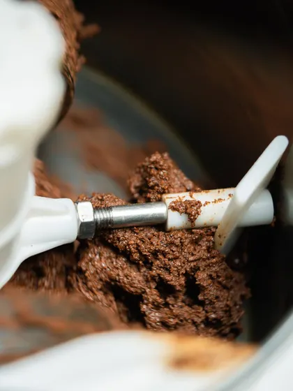The grinding process in a melanger, where roasted cacao nibs are slowly refined into smooth, liquid chocolate. This can take hours, even days, to achieve the perfect texture.