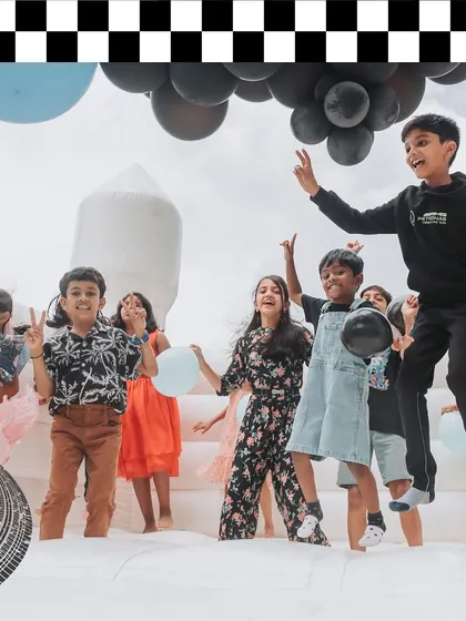 Kids having a blast in an all-white bouncy castle. I provide entertainment options that fit the event's aesthetic, like this chic and modern inflatable.