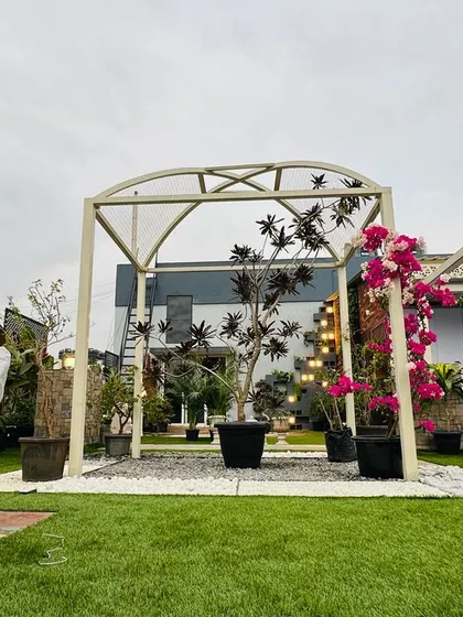 This simple yet elegant arched pergola serves as a beautiful frame for a garden pathway and entrance. We trained vibrant bougainvillea to climb the structure, adding a splash of color and natural beauty to the hardscaped arch.