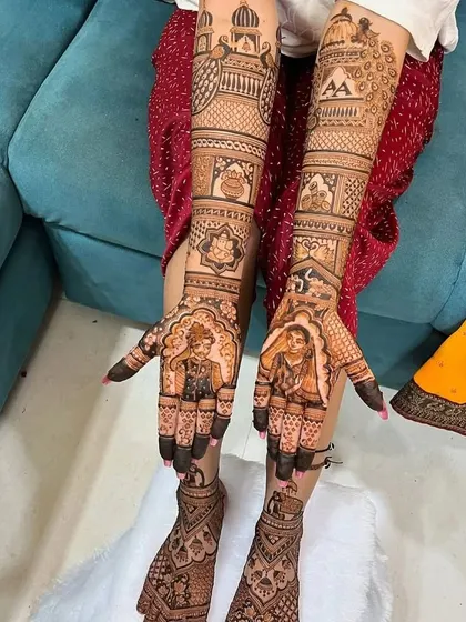 A full bridal set featuring custom portraits of the bride and groom on the palms. The design extends to the feet, maintaining a consistent theme with traditional motifs and the couple's initials.