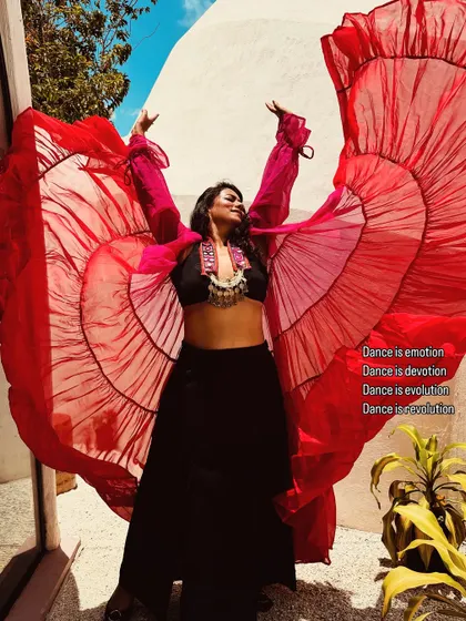 Let's dance our own light and fly high! A shot from a photoshoot celebrating International Dance Day, with wings made of red fabric to symbolize freedom and passion.