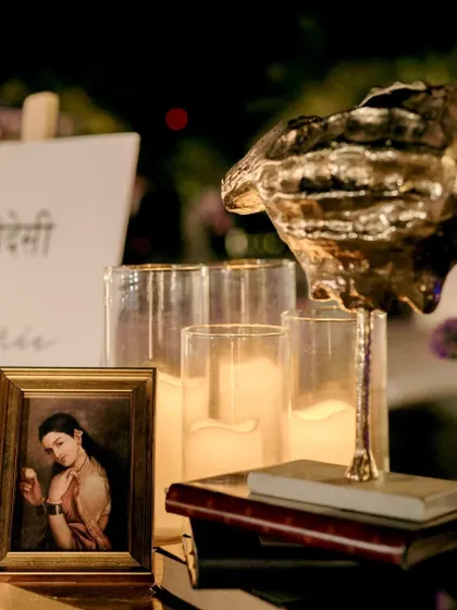 A collection of vintage-style props, including a conch shell, old books, and candles.