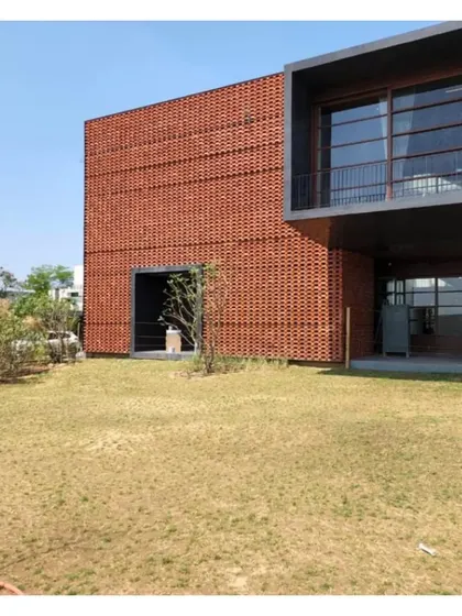 The Ishtika house, with its distinctive brick jali facade, sits in the landscape. The home looks inwards, celebrating private family life within its porous, breathing walls. We never worry about doing too little.