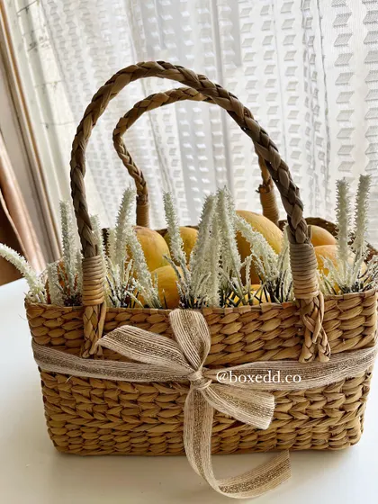 A perfect gift for a summer wedding or event. This rustic woven basket filled with fresh mangoes is a unique and delicious way to welcome guests or send them off with a sweet thank you.
