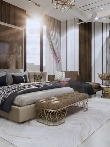 Sunlight streams into this beautifully appointed master bedroom, highlighting the luxurious textiles and elegant furniture. The layout includes a cozy seating area, making it a perfect private retreat.