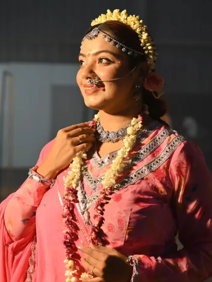 Bathed in a golden glow, this shot captures the serene and radiant smile of Radha. The natural flower jewelry was a key element of this authentic look.