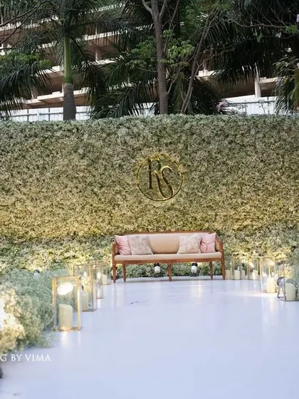 An ethereal all-white reception. The aisle and backdrop are adorned with clouds of baby's breath, while flickering candles cast a warm, romantic glow, creating a scene straight out of a fairy tale.