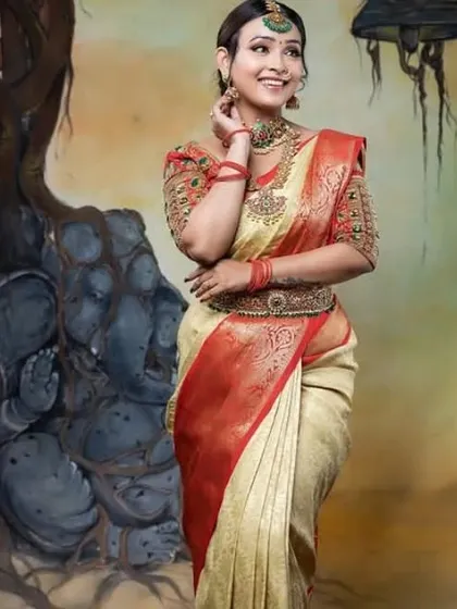 A full-length shot of a model in a traditional cream and red saree, wearing our rental kundan jewellery set.