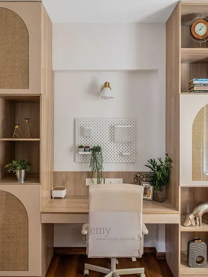 This neutral workspace has it all: ample storage, a spacious desk, and a hidden mandir. The use of cane and arches keeps the design light and sophisticated.