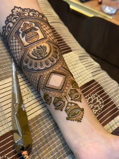 Another view of the arm band in progress, with the henna cone visible. This shows the fresh, dark paste we use to ensure a beautiful, long-lasting stain.