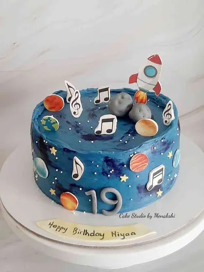 A galaxy themed cake for someone who loves music and the planets. The deep blue buttercream is decorated with planets and musical notes.