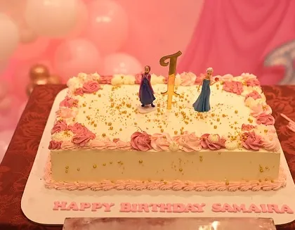 The birthday cake for Samaira's party, topped with Frozen figurines, blending two popular princess themes.