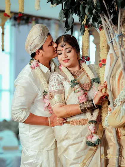 A tender embrace during a traditional wedding. The groom's gentle kiss on the bride's forehead is a timeless expression of love.