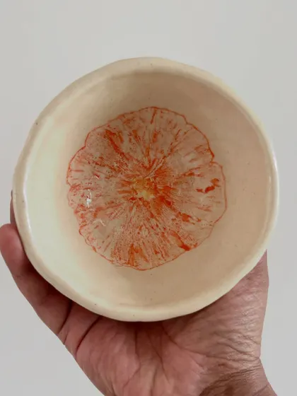 This small, hand-built bowl was decorated by a student using a flower transfer technique with underglaze.