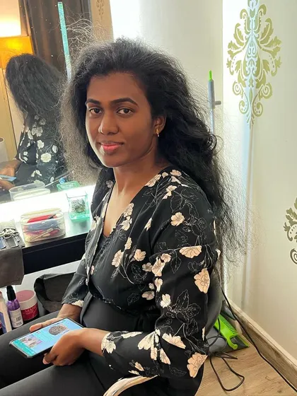Monisha's long curly hair before her big chop for a good cause.