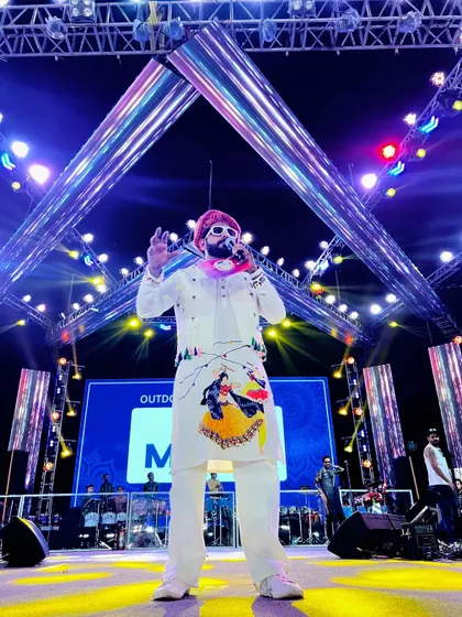 A full-length shot on the beautifully lit stage of Rangraas Navratri, wearing a custom-painted white traditional outfit.
