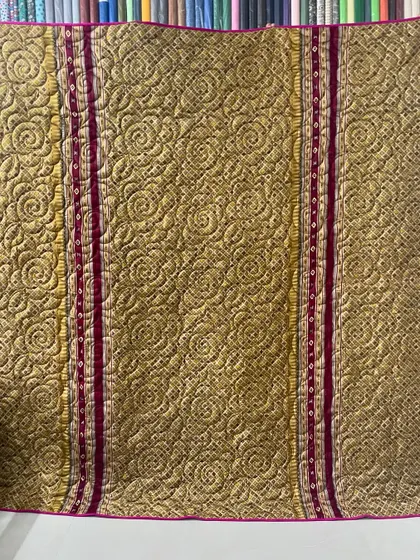 This reversible memory quilt was crafted from a beautiful gold and magenta saree, preserving its vibrant colors and patterns.