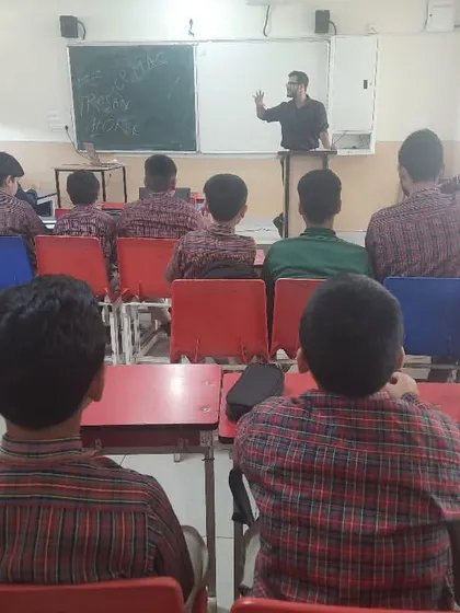 A view from the back of the classroom shows students fully engaged as the instructor explains a topic.