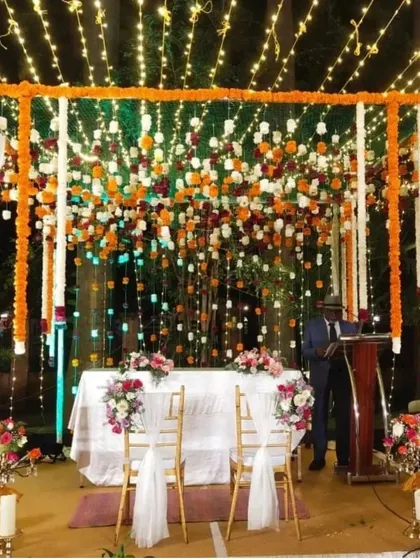We created this spectacular floral mandap using a cascade of fresh marigolds and white flowers under a canopy of string lights. The design is both traditional and breathtaking, perfect for a memorable wedding ceremony.