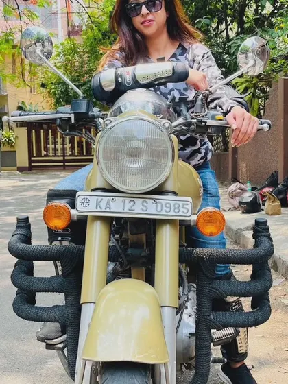 A graduate sits confidently on her Royal Enfield, a picture of empowerment. She is ready to take on the world, one ride at a time.