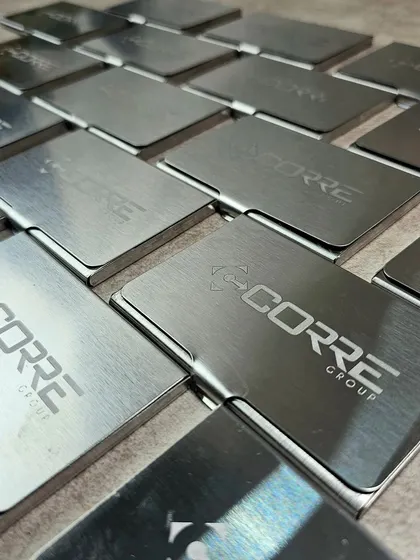 Duplicate of 56. A bulk order of sleek, brushed metal card holders, each engraved with the "Corre Group" logo. These make for a professional and practical corporate gift.