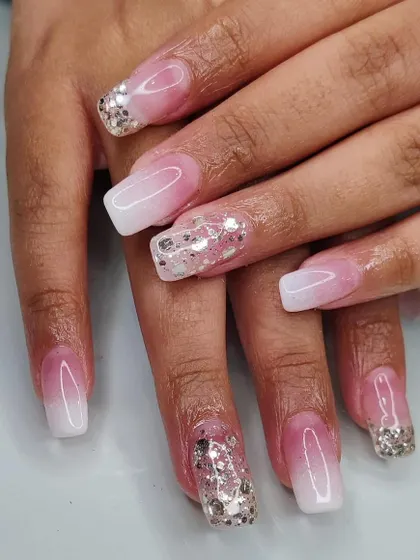 A dramatic ombré look on square nails, combining a pink and white gradient with chunky silver glitter accents for maximum sparkle.