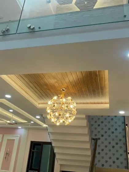 A wide shot showing the glass floor detail and the elegant staircase. This view highlights how we use architectural elements and lighting to create a cohesive and impressive interior.