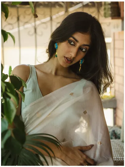 Using natural elements like plants to frame the subject adds depth and a sense of intimacy to the portrait. The soft light is perfect for this gentle, elegant look.