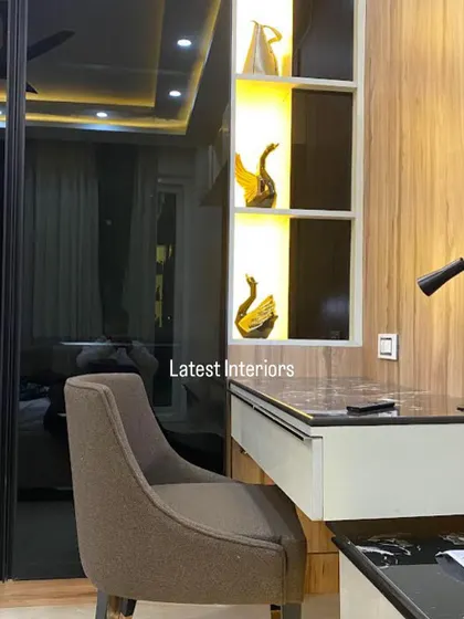A close-up of the study nook next to the black glass wardrobe. The illuminated display shelves are perfect for showcasing decorative items.