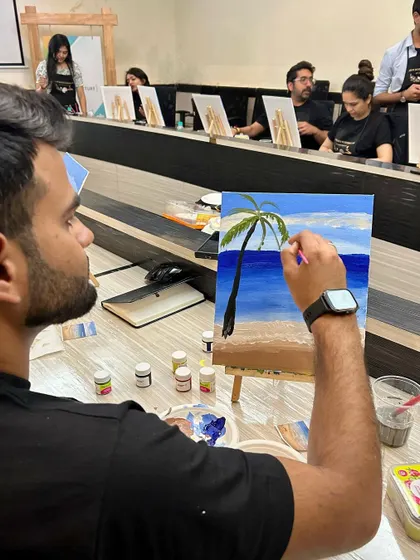 Adding a palm tree to the beach painting. It's wonderful to see participants adding their own creative flair.