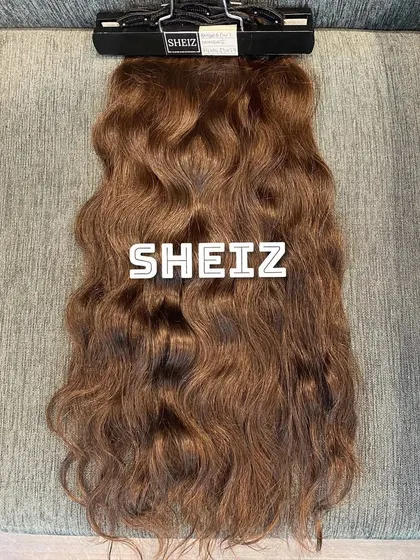 This set of wavy clip-on extensions is ready for a client. We provide a hanger for easy storage to maintain the hair's quality.