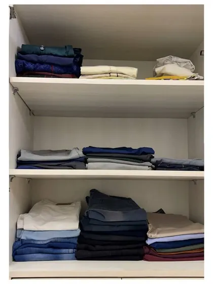 On the shelves below, we neatly stacked all the folded items like t-shirts, trousers, and jeans, categorizing them for easy access.