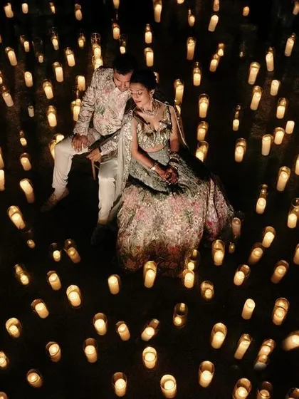 A stunning aerial shot of the couple sitting in a sea of candles.