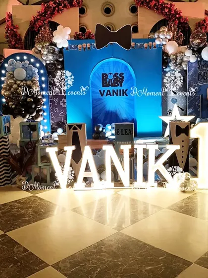 A wide view of a luxurious "Boss Baby" setup, featuring a custom stage, marquee letters, and themed props all under dramatic lighting.