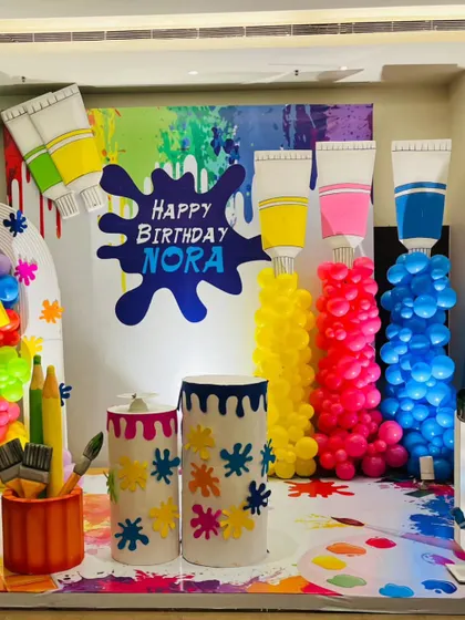 A wider view of the art party setup, including a large light-up number '6' and custom-painted barrels that enhance the creative theme.
