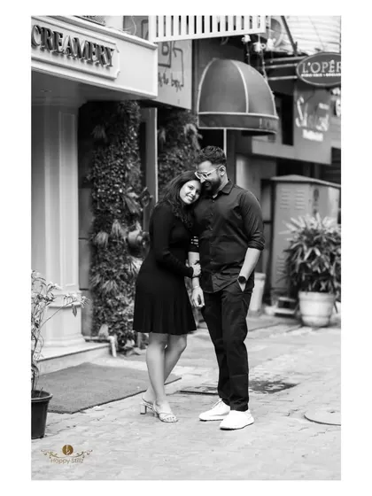A timeless black and white photo of a couple sharing a quiet moment on a city street. It shows that even in a busy urban setting, we can find and capture intimate connections.
