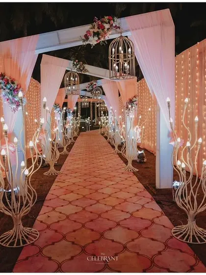 A modern and stylish entrance for a reception, featuring a patterned carpet and unique tree-like light fixtures.