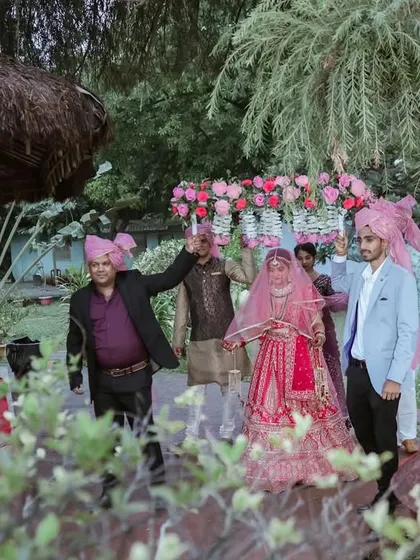 The bride's entry under a beautiful 'phoolon ki chadar' held by her brothers. A classic and emotional moment in Indian weddings.