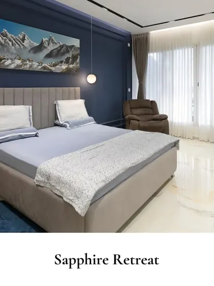 This bedroom is a perfect fusion of striking colors and modern textures. The deep sapphire accent wall is complemented by a large piece of art, while the integrated desk creates a functional corner for work or study.