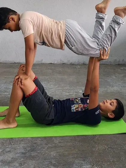 A smiling base and a focused flyer make this acro-yoga pose a perfect picture of the fun and achievement our campers experience.