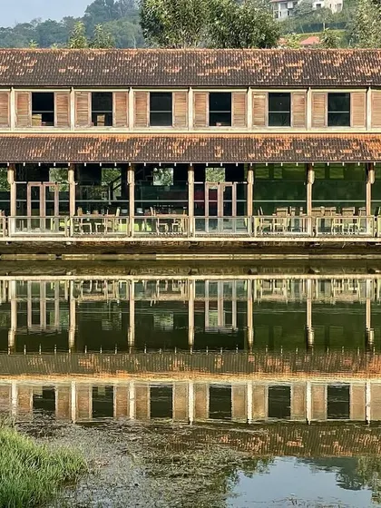 A frontal view of the ODEA' restaurant, showcasing its vernacular-inspired design with a long veranda overlooking the water. The building is a testament to how modern construction techniques can be paired with traditional aesthetics.