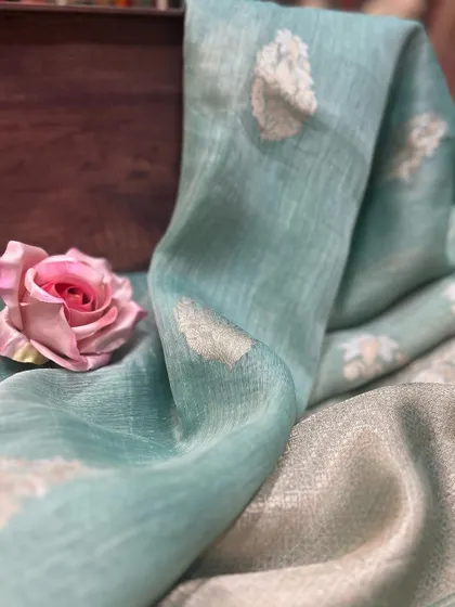 The subtle beauty of a handwoven Tissue Silk saree. This image captures the light passing through the sheer fabric, highlighting the delicate silver buti work.