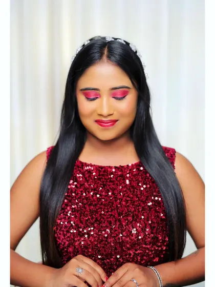 A close up showing the details of this party makeup. The bright pink eyeshadow is blended perfectly, and the skin has a radiant finish, complemented by a simple hair accessory.