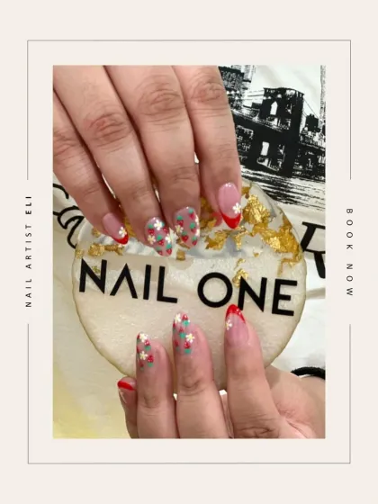 A creative twist on a French manicure, featuring tiny, hand-painted strawberries and a bold red tip. This design, created by our artist Eli, shows how we can personalize a classic look with charming details.