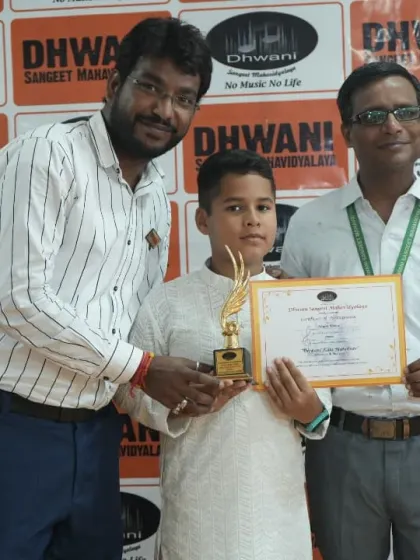 Teachers presenting an award to their student, a moment of shared pride and accomplishment.