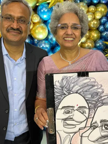 This elegant couple posed in front of the party decorations with their caricature.